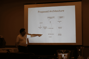 Image of a man pointing at a presentation of an architecture