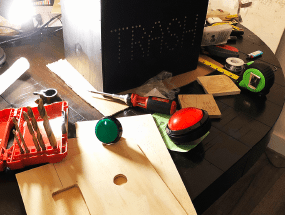 Control buttons on a table, plank of wood with holes cut out in it