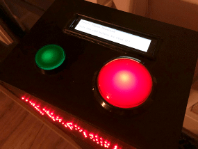 A top-down view of trashbox, a red and green button can be seen with an LCD screen